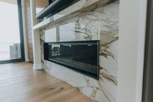 A fireplace inset into a stone slab with natural veining. 